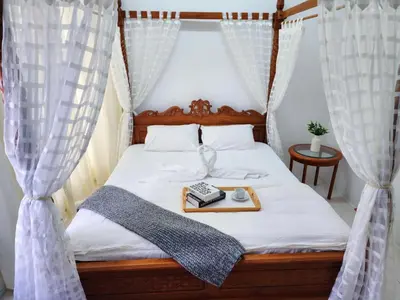 a bed with curtains and a tray with a phone on it at IPOH Chemor Casa Klebang, 5 PAX Fully Air-Con Homestay in Chemor