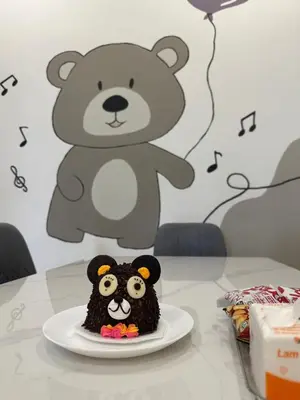 a cake on a plate on a table with a teddy bear at Pantai Remis Bear Homestay in Pantai Remis