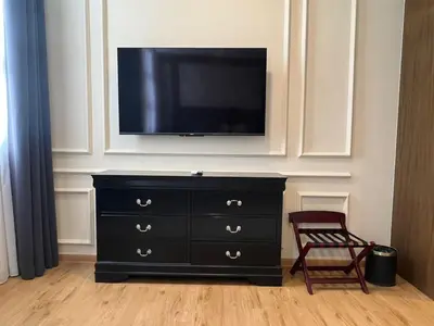 a black dresser with a television on top of it at The Leith in George Town