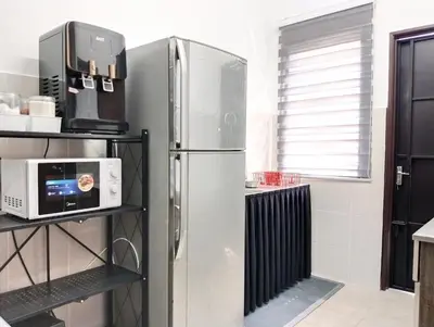 a stainless steel refrigerator in a kitchen with a microwave at UR Homestay, Seri Iskandar in Seri Iskandar