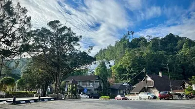 a town with cars parked in front of a mountain at Silverpar B5-5-1 Mountain View(walk up 2 floor up) in Bukit Fraser