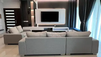 a living room with a couch and a flat screen tv at Grand’e La Villa Homestay in Lumut