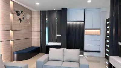 a living room with a couch and a chair at Grand’e La Villa Homestay in Lumut