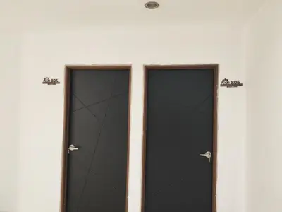 two black doors on the side of a white building at Cozy Roomstay Padang Serai in Padang Serai