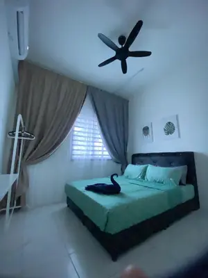 a bedroom with a black bird on a bed with a ceiling fan at Abu Fateh Homestay in Seri Iskandar
