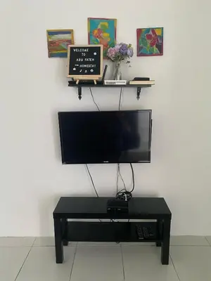 a flat screen tv sitting on a wall with a table at Abu Fateh Homestay in Seri Iskandar