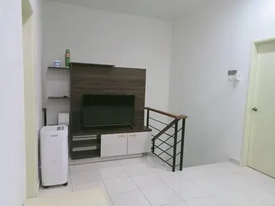 a living room with a television and a staircase at MR OT HOMESTAY ( BAITUL RAUDHAH ) in Kepala Batas