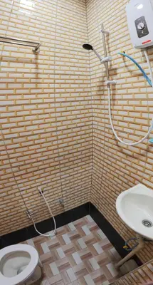 a bathroom with a shower and a toilet and a sink at Santai Desa Chalet musleem 0nly in Brinchang
