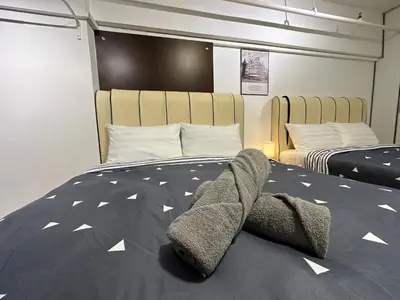 a bedroom with a bed with a comforter on it at CEOZ2 Duplex 2BR Suite #Airport #USM #SPICE #Pantai in Bayan Lepas