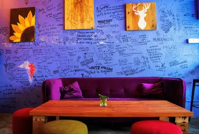 a purple couch with a table and some pictures on a wall at Rope Walk Guest House in George Town