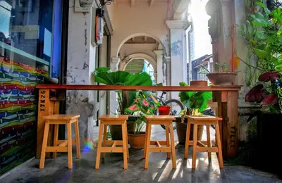a table and four stools in front of a building at Rope Walk Guest House in George Town