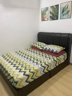 a bed with a black bed frame and a rug at D' Permata Homestay Kulim in Kulim