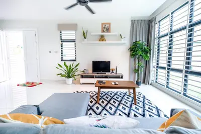 a living room with a blue couch and a table at Solok Sungai Emas By Plush in Batu Ferringhi
