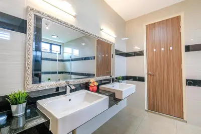 a bathroom with two sinks and a large mirror at Solok Sungai Emas By Plush in Batu Ferringhi