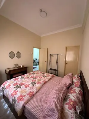 a bedroom with a bed and a table and mirror at DHW Homestay in Simpang Ampat Semanggol