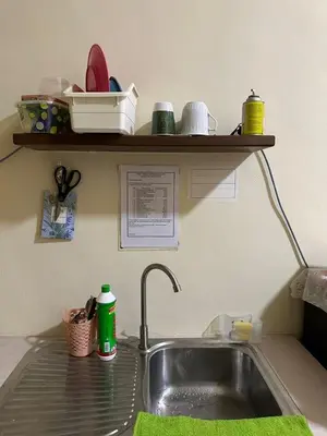 a kitchen sink with a green sponge next to it at DHW Homestay in Simpang Ampat Semanggol