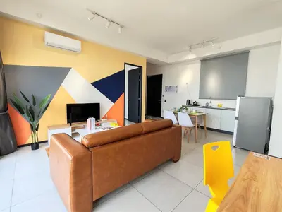 a living room with a couch and a kitchen at Urban Simplicity Suite, 5 Pax, 2 Car Parks at Urban Suites Georgetown by SuperStay in Jelutong