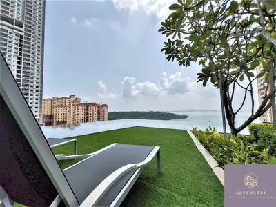 a white chair on a lawn with a view of the water at Urban Simplicity Suite, 5 Pax, 2 Car Parks at Urban Suites Georgetown by SuperStay in Jelutong