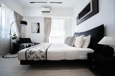 a white bedroom with a bed and a window at Batu Ferringhi By The Sea Luxurious 2BR Suite 6 Pax in Batu Ferringhi