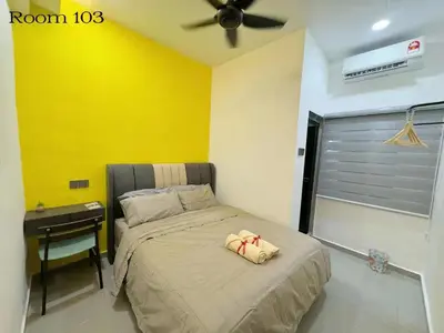 a bedroom with a bed and a desk with a fan at 82,Dream Guest House in Tanjung Piandang