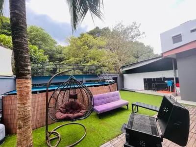 a backyard with a hammock and a purple couch and a tree at Nature Surrounded Riverside Villa with BBQ ,& SWIMMING POOL in George Town