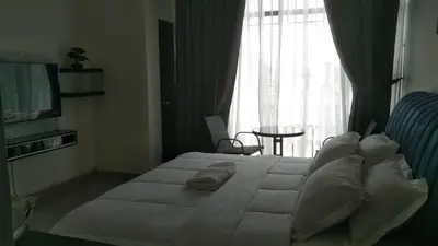 a bedroom with a large white bed and a window at RJ Studio 1 - Kompleks Mutiara in Gua Musang