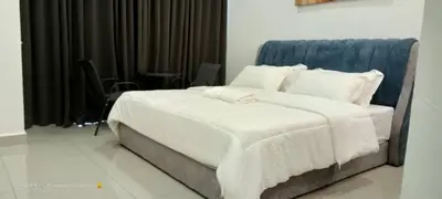 a bed with white sheets and pillows in a room at RJ Studio 1 - Kompleks Mutiara in Gua Musang