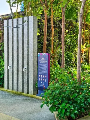 a sign in front of a fence next to a bush at Tropicana 218 Macalister by NGN in George Town