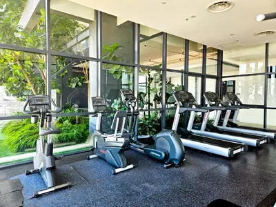 a gym with rows of cardio machines in a building at Tropicana 218 Macalister by NGN in George Town