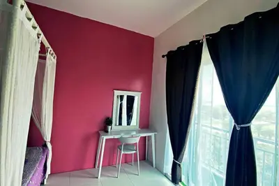 a room with a pink wall with a mirror and a chair at R&R Manjung Guest House at Pangsapuri Samudera in Seri Manjung