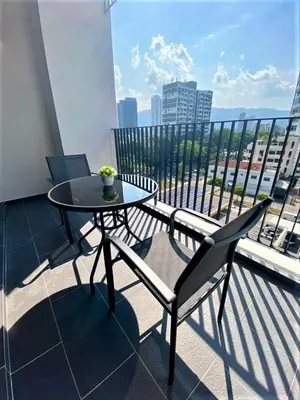 a table and a chair on a balcony at Corner Club Penang in George Town