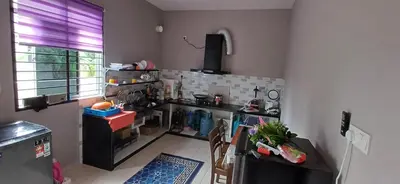 a kitchen with a counter and a table with chairs at teratai ciknah in Penaga