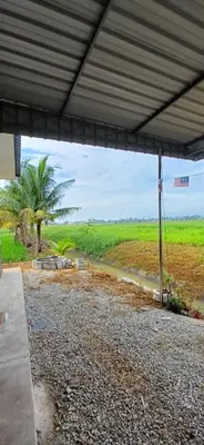 a view of a field from under a building at teratai ciknah in Penaga
