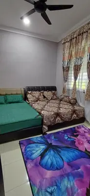 a bedroom with two beds and a butterfly rug at teratai ciknah in Penaga
