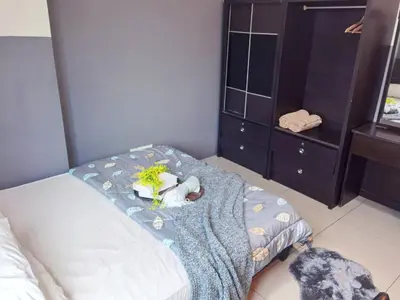 a bedroom with a bed with a blue blanket and a dresser at Kinta Riverfront Apartment, Jalan Lim Bo Seng Ipoh in Ipoh