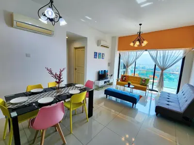 a dining room and living room with a table and chairs at Kinta Riverfront Apartment, Jalan Lim Bo Seng Ipoh in Ipoh