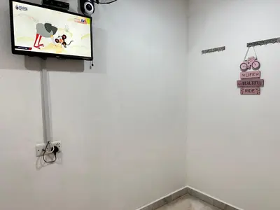 a flat screen tv hanging on a white wall at Comfortable Homestay Ipoh 6R6B 9pax SY30 in Ipoh