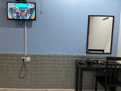 a tv on a wall with a mirror and a table at Comfortable Homestay Ipoh 6R6B 9pax SY30 in Ipoh