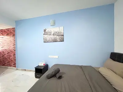 a bedroom with a bed and a blue wall at Comfortable Homestay Ipoh 6R6B 9pax SY30 in Ipoh