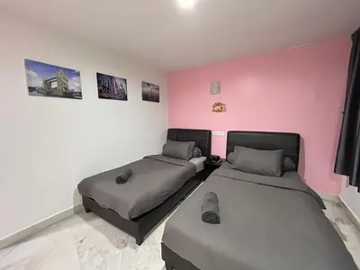 a bedroom with two beds and a pink wall at Comfortable Homestay Ipoh 6R6B 9pax SY30 in Ipoh