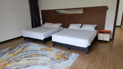 a hotel room with two beds and a rug at ZINNIA RESIDENCE in Tanah Rata