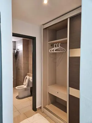 a bathroom with a toilet and a glass door at Metropol Serviced Apartment Bukit Mertajam Perda in Bukit Mertajam