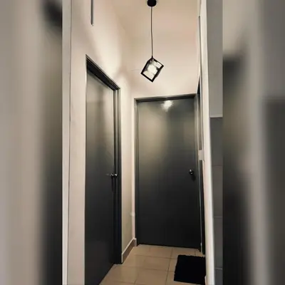 a hallway with two doors and a light fixture at Prima Falim in Ipoh