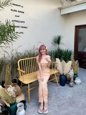a woman is sitting on a bench next to plants at The Palm Suite Tanjung Tokong in George Town