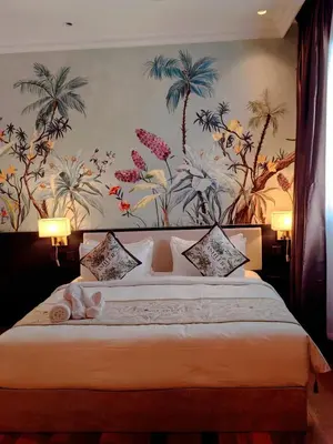 a bedroom with a large bed with a floral wallpaper at The Palm Suite Tanjung Tokong in George Town