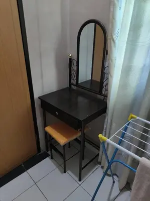 a black dressing table with a mirror and a chair at HomeStay Pulai in Ipoh