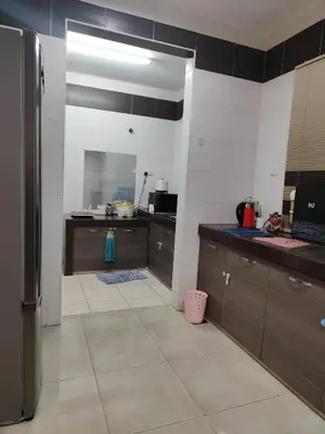 a kitchen with black and white walls and brown cabinets at Casa Margosa Homestay in Ipoh