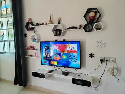 a room with a tv on a wall with shelves at Padang Serai Cozy Roomstay Share Bathroom in Padang Serai