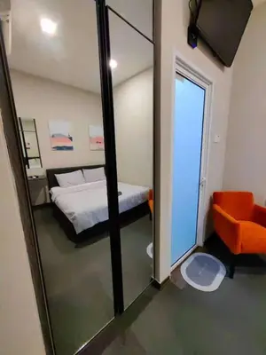 a bedroom with a bed and a mirror and a chair at Maritime Cozy Suite @ Penang Georgetown in Jelutong