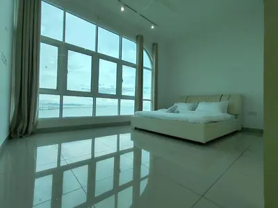 a white room with a couch and a large window at Invincible Seaview Vacation Condo 3R3B 8Pax in Bayan Lepas